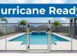 A secure mesh safety fence around a clear pool before a storm.