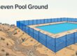Blue mesh fencing follows uneven ground beside a turquoise pool.