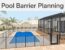 Blue pool with a mesh safety fence, gate, and screened lanai.