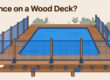 A mesh safety fence is anchored to a wooden deck beside a blue pool.