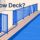 A blue mesh fence and inward-swinging gate border a narrow pool deck.